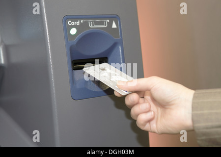 Donna inserimento carta di credito nello sportello bancomat Foto Stock