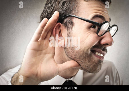 Lavoratore di ufficio con gli occhiali non riesce a sentire qualcuno Foto Stock