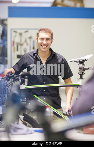 Metà uomo adulto in officina di riparazione con noleggio biciclette Foto Stock