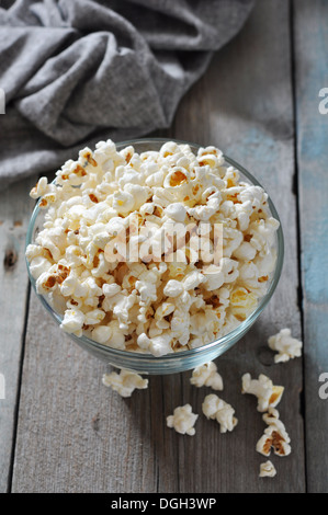 Il Popcorn in recipiente di vetro sopra lo sfondo di legno Foto Stock