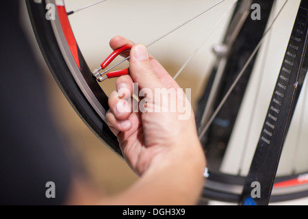 Close up della persona che usa il parlato chiave sulla ruota di bicicletta Foto Stock
