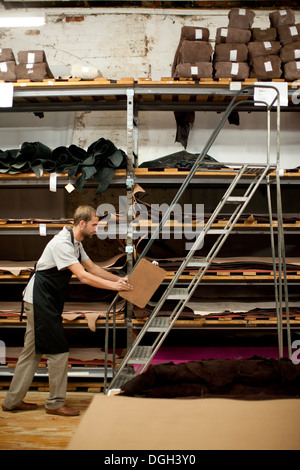 Giovane uomo che lavora in magazzino in pelle Foto Stock