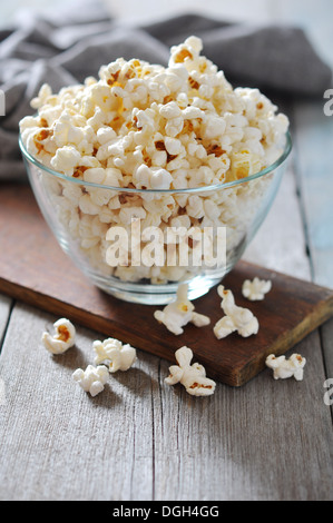 Il Popcorn in recipiente di vetro sopra lo sfondo di legno Foto Stock