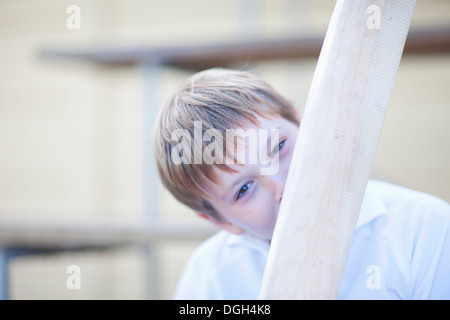 Ragazzo holding cricket bat nella parte anteriore del viso Foto Stock