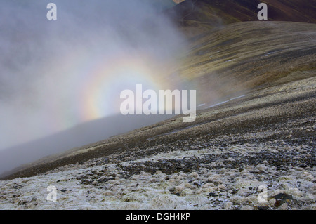 Brocken spectre visto dalla cima della collina viene visualizzato quando il sole splende da dietro la persona che sta guardando verso il basso dalla cresta o cima nella nebbia Foto Stock