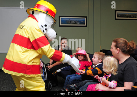 Sparky, 4 Ingegnere Civile squadrone di prevenzione antincendio mascotte, mani caschi per bambini da bambino centro di sviluppo durante un incendio prevenzione settimana gita presso Seymour Johnson Air Force Base, N.C., Ottobre 9, 2013. Cucina la prevenzione degli incendi è il tema di t Foto Stock