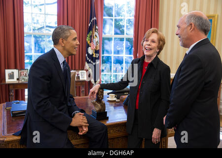 Il Presidente Usa Barack Obama parla con Carol Burnett, il 2013 destinatario del Mark Twain Prize per American umorismo, e suo marito Brian Miller nell'Ufficio Ovale della Casa Bianca ott. 21, 2013 a Washington, DC. Foto Stock