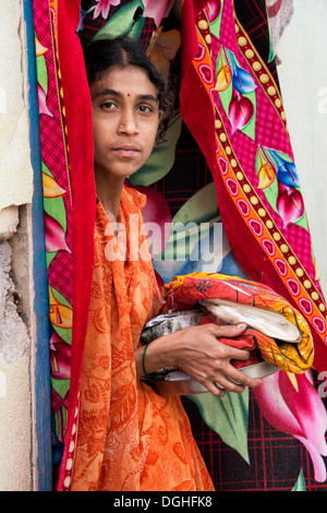 Rurale villaggio indiano donna con doni di cibo e vestiti dato da Sri Sathya Sai Baba organizzazione. Andhra Pradesh, India Foto Stock