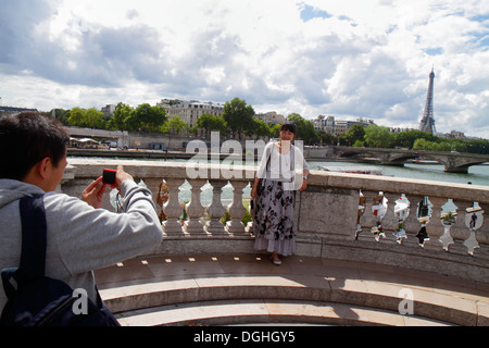 Parigi Francia,Fiume Senna,Pont Alexandre III,ponte,Torre Eiffel,uomo asiatico uomo maschio,adulto,adulti,donna donna donne,prendendo Pont des Invalides,France130 Foto Stock