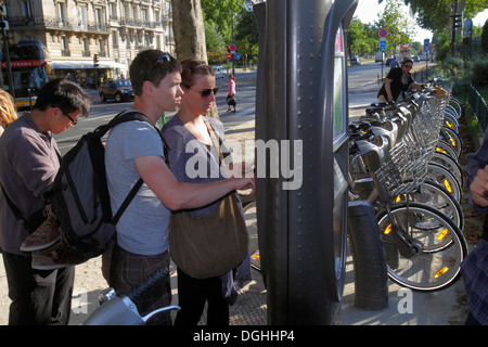 Parigi Francia,7° arrondissement,Quai Branly,Velib bike share system,stazione,noleggio biciclette,uomo uomini maschio,adulto,adulti,donna donna donne,chiosco,self ser Foto Stock