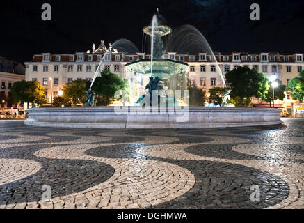 Fontane e modelli di onda in cobblestone pavement su piazza del Rossio o Praça Dom Pedro IV, Lisbona, Portogallo, Europa Foto Stock