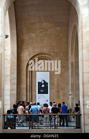 I visitatori e i turisti di fronte al segno di direzione per la Mona Lisa hall nel Musée du Louvre, Parigi Foto Stock