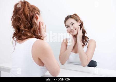 Una ragazza sottile cercando in uno specchio Foto Stock