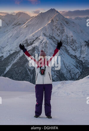 Donna con le braccia aperte in piedi di fronte a un panorama alpino, Mt Rauher Kopf montagna da Venet montagna, Venet, Zams Foto Stock