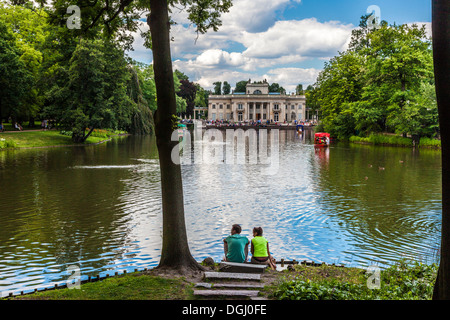 Un giorno di estate in riva al lago nel Parco Lazienki a Varsavia con il palazzo nella distanza. Foto Stock