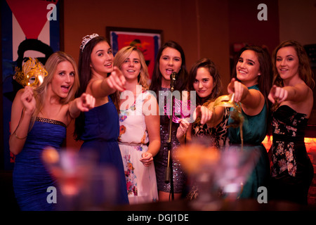 Le giovani donne a cantare in un karaoke bar Foto Stock