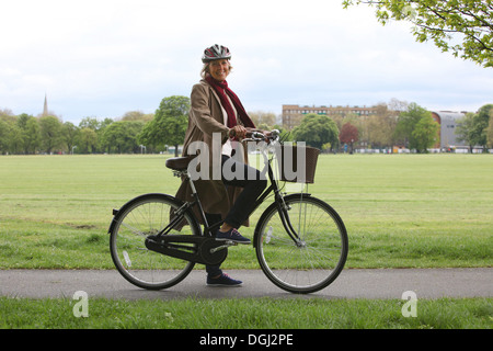 Senior donna bicicletta equitazione nel parco, ritratto Foto Stock