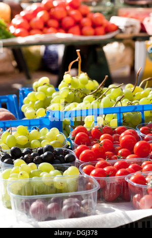 Uva e pomodori in scatole di plastica. Foto Stock