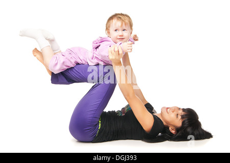 La madre con il bambino a fare gli esercizi su bianco Foto Stock