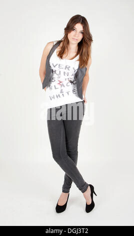 Giovane donna che indossa un top bianco e grigio jeans Foto Stock