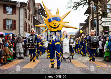 Grande tamburo di un gruppo Guggen, carnevale marching band, vestito come il sole, 35th Motteri parade di Malters, Lucerna Foto Stock