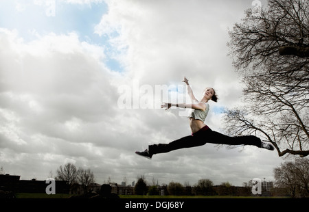 Donna facendo ballet leap Foto Stock