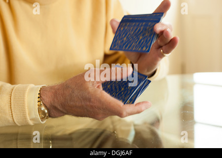 Close up di vecchie mani rimescolare le carte da gioco Foto Stock