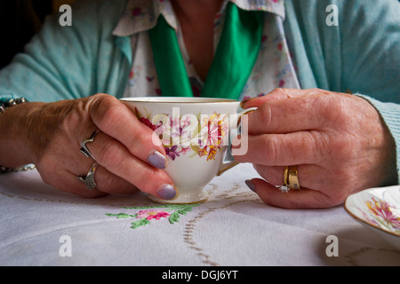 Una donna di mani tenendo una tazza di tè. Foto Stock