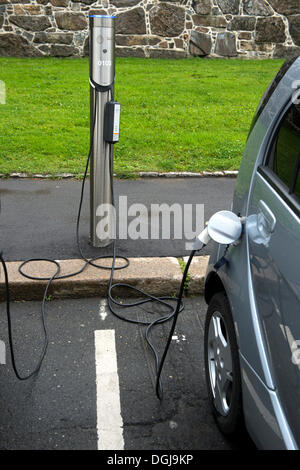 Un auto elettrica di ricaricare la batteria di un veicolo elettrico stazione di carica in un parcheggio nel centro di Oslo, Norvegia Foto Stock