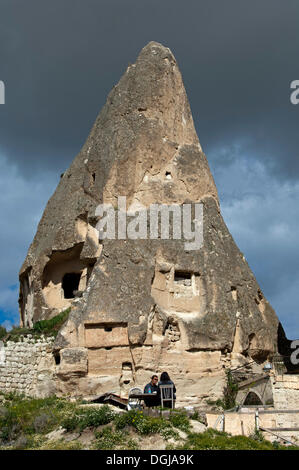 Un tufo scavato cono o fata camino, due persone sedute a un tavolo in primo piano, il Parco nazionale di Göreme, Göreme Foto Stock