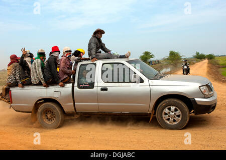 Piccolo camioncino che trasportano i lavoratori agricoli nell'affollato cargo bay su una strada di campagna, Cambogia Foto Stock