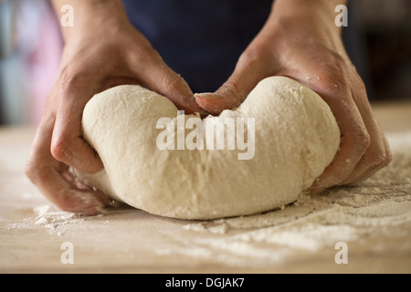 Close up di mani impastare la pasta di pane Foto Stock