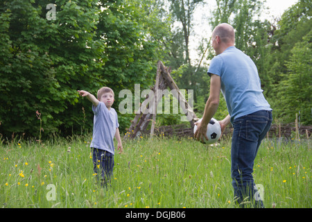 Padre e figlio giocando con il calcio Foto Stock
