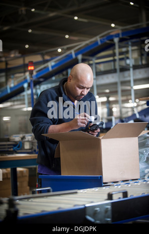 Magazzino maschio lavoratore utilizzando uno scanner di codici a barre Foto Stock