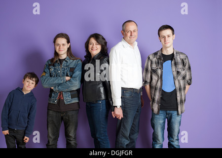 Ritratto di famiglia di cinque persone di fronte a sfondo viola Foto Stock