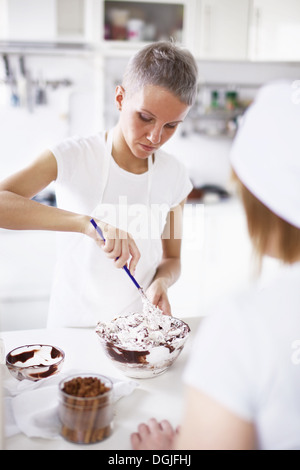 Donna torta di miscelazione miscela nel recipiente Foto Stock