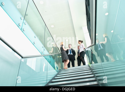 I colleghi in piedi sulla scalinata di edificio per uffici Foto Stock