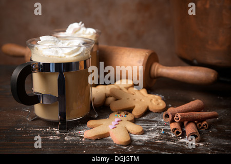 Gli uomini di panpepato cookie biscotti con caffè caldo e panna montata Foto Stock