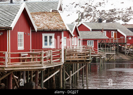 Villaggio di Pescatori con casette rosso accanto a un fiordo in inverno, la Reine, Lofoten, Nordland, Norvegia settentrionale, Norvegia Foto Stock