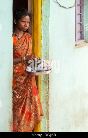 Casta inferiore Indian ragazza adolescente riceve gratuitamente il cibo e vestiti al di fuori di casa sua. Andhra Pradesh, India Foto Stock