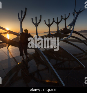 Adolescente dal Solfar Viking Ship, godendo il sole di mezzanotte, Reykjavik, Islanda Foto Stock