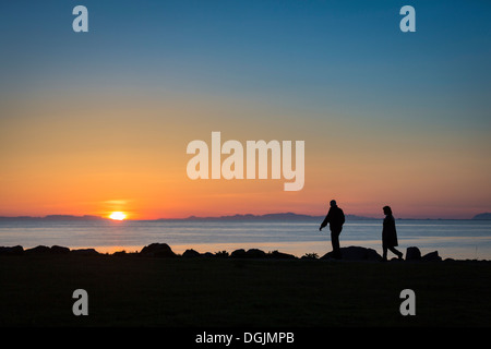 Giovane godendo di una passeggiata sotto il sole di mezzanotte, Seltjarnarnes, Reykjavik, Islanda Foto Stock