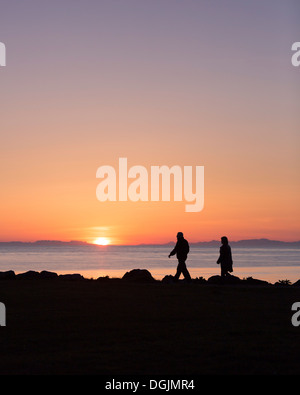 Giovane godendo di una passeggiata sotto il sole di mezzanotte, Seltjarnarnes, Reykjavik, Islanda Foto Stock