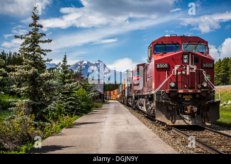 Un treno merci e il motore al Lago Louise stazione ferroviaria con paesaggio di montagna nel Parco Nazionale di Banff, Alberta, Canada. Foto Stock