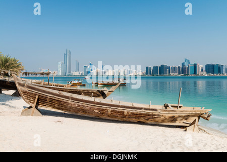 Skyline del moderno Abu Dhabi e vecchie imbarcazioni di pesca artigianale nel Villaggio del Patrimonio Culturale di Abu Dhabi negli Emirati Arabi Uniti EMIRATI ARABI UNITI Foto Stock