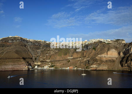 Vista dal mare verso il porto e la città capitale di Fira o Thira, SANTORINI, CICLADI, isole greche, Grecia, Europa Foto Stock