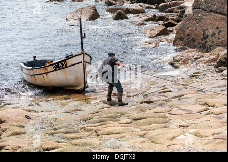 Un pescatore della Cornovaglia recuperando la sua barca da pesca in Penberth Cove. Foto Stock