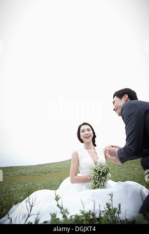 Un groom tenendo una mano spose nella natura Foto Stock