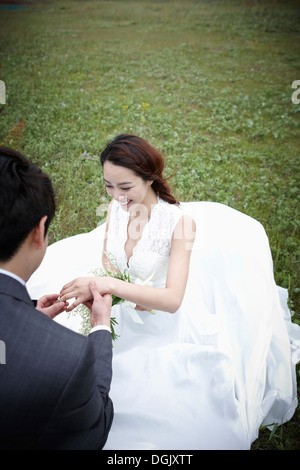 Un groom tenendo una mano spose nella natura Foto Stock