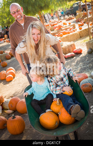 Adorabili giovane famiglia gode di una giornata presso la Zucca Patch. Foto Stock